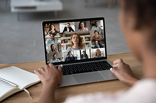 A Zoom meeting is displayed on a laptop screen.