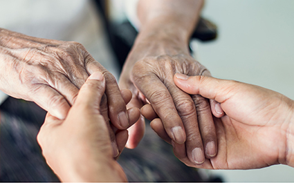 A doctor holds a patient's hands.