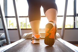 Close up of feet walking on treadmill.