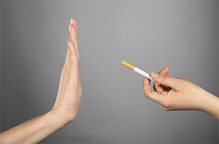 A hand refuses a cigarette.