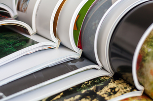 A stack of journals lie open, nested together.