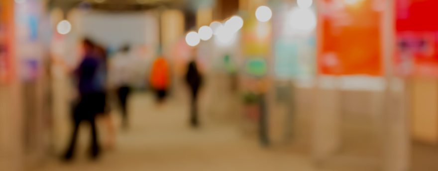 An out of focus image of people browsing a poster session.