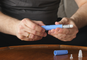A man prepares to inject a dose of Ozempic.